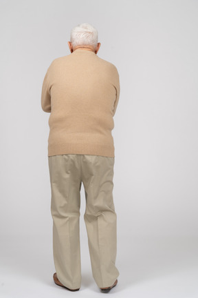 Rear view of a scared old man in casual clothes