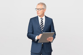 Elegant middle-aged business man using his tablet