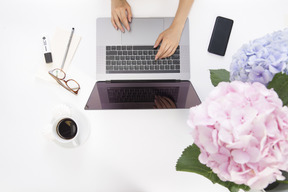 Mains féminines en tapant sur l'ordinateur portable