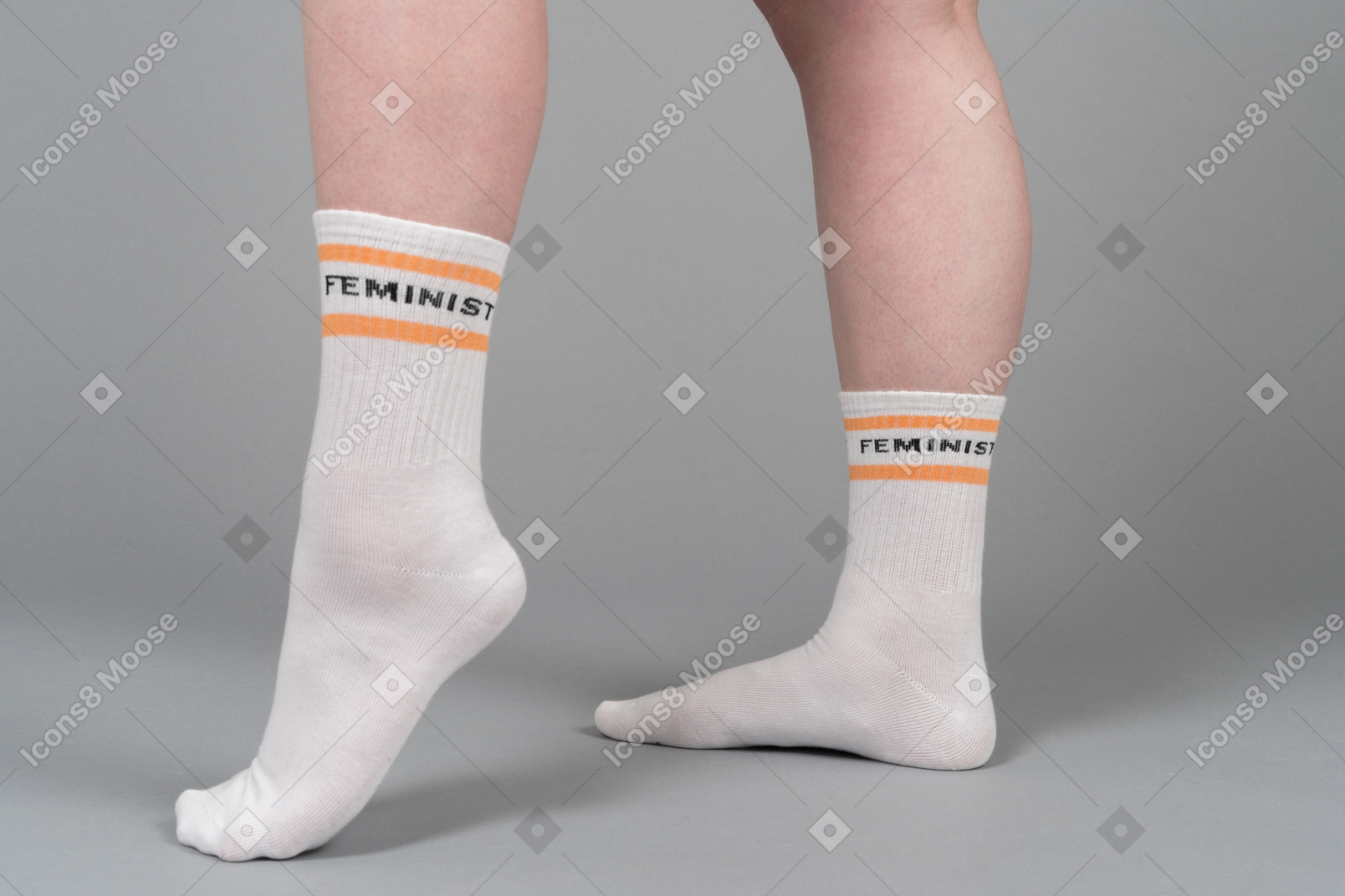 Piedi femminili in calzini su sfondo grigio