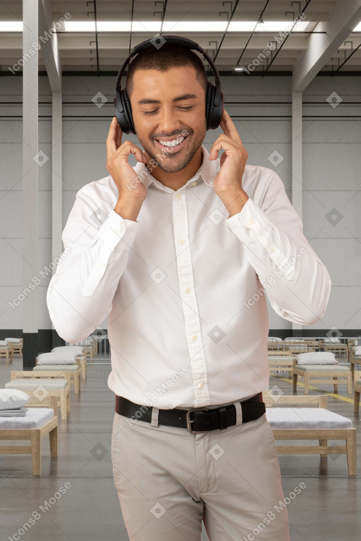 病院でヘッドフォンで音楽を聴いている男性