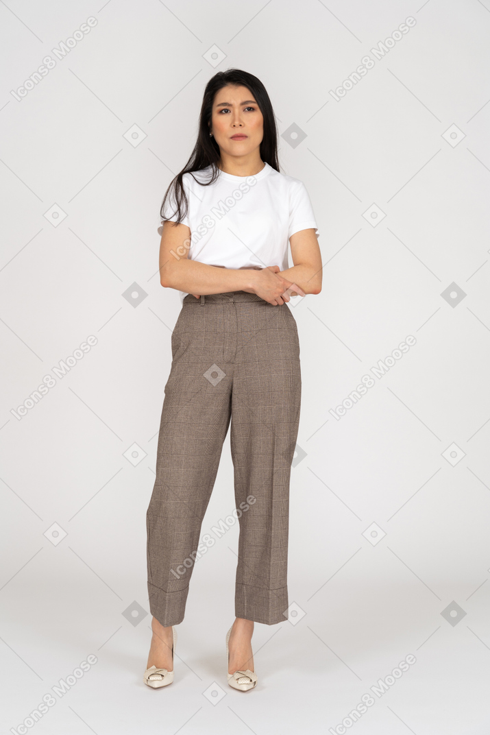Front view of a displeased young lady in breeches and t-shirt crossing hands