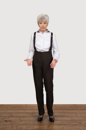 Front view of a gesticulating questioning old lady in office clothing