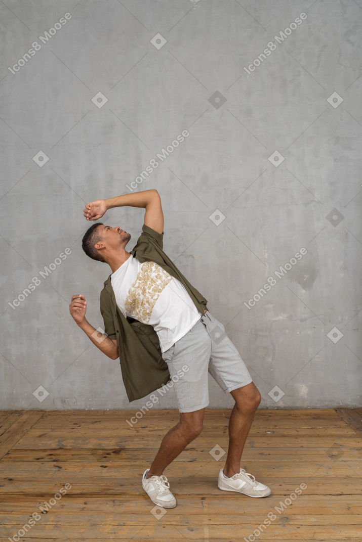 Man in casual clothes leaning backwards with hands up