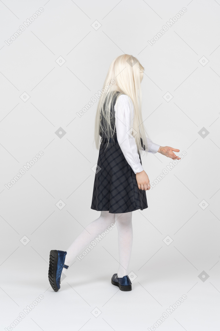 Back view of a schoolgirl reaching down