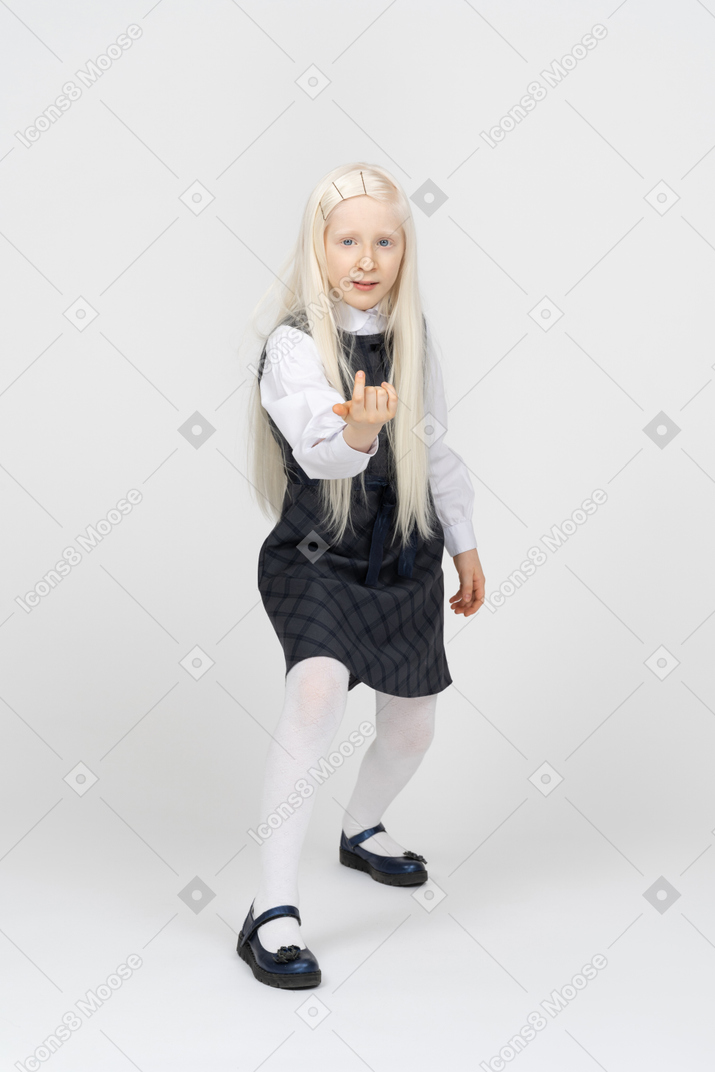 Schoolgirl with long hair beckoning with finger