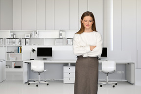 A woman standing in front of a desk in an office