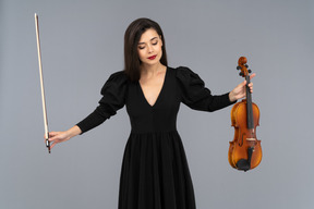 Vista frontale di una violinista in abito nero che fa un inchino