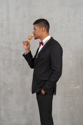 Side view of young man enjoying a glass of champagne