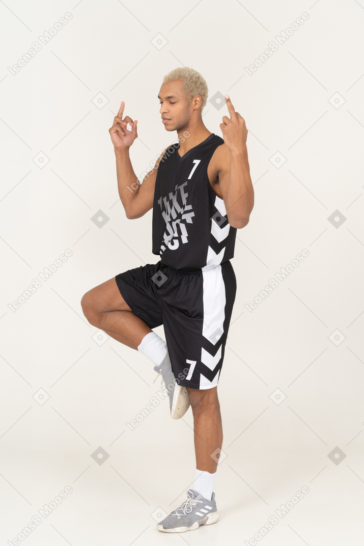 Three-quarter view of a meditating young male basketball player showing middle fingers