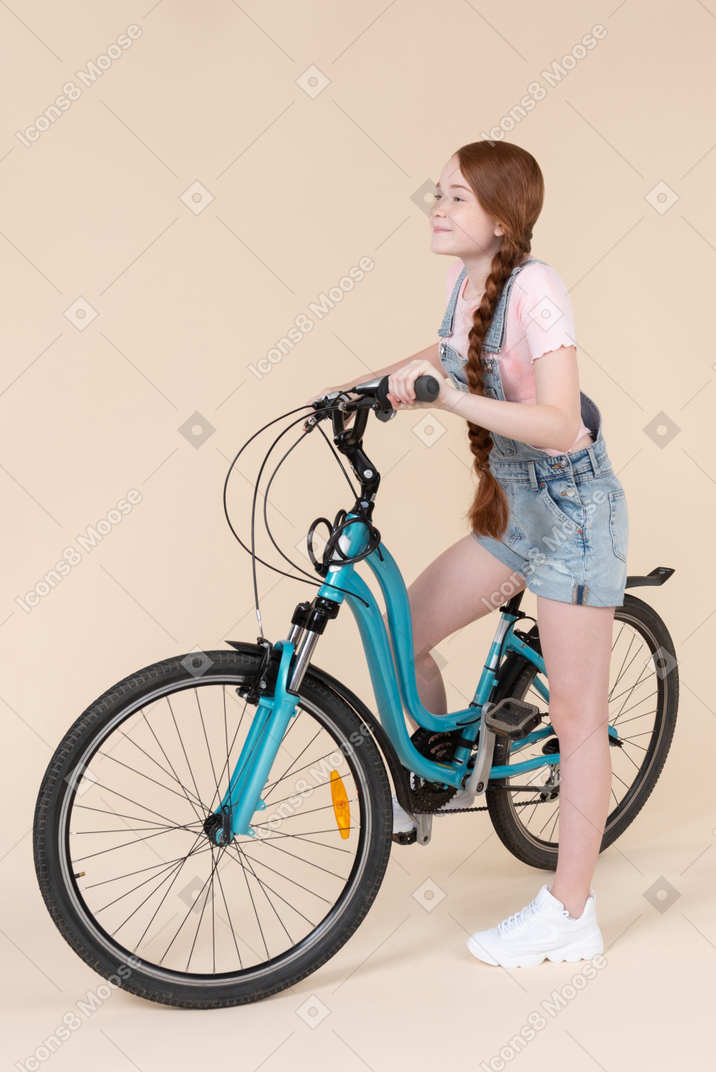 Teenage girl riding on blue bicycle