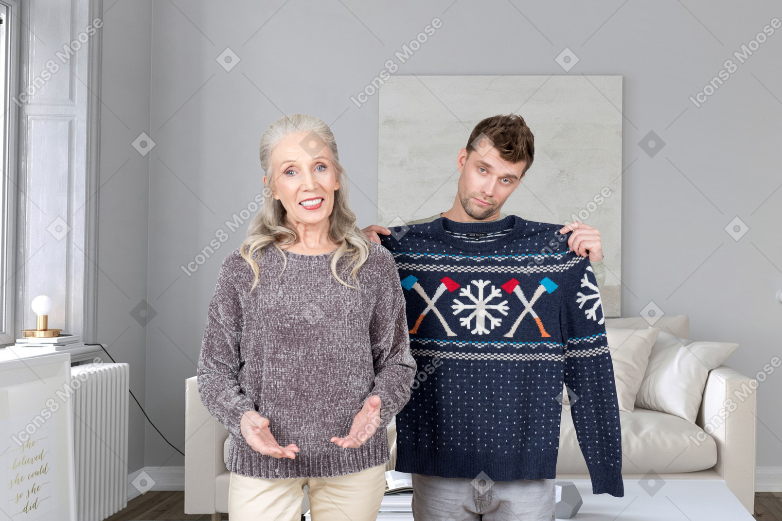 Elderly woman standing next to man holding christmas sweater