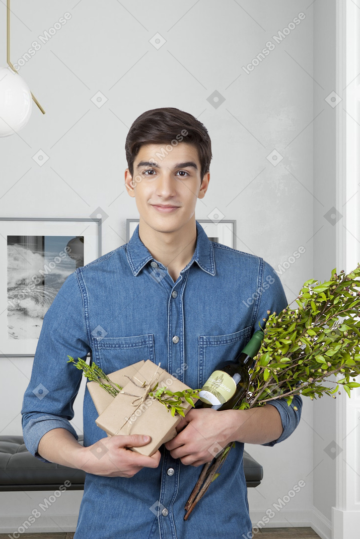A man holding a bouquet of flowers and a bottle of wine
