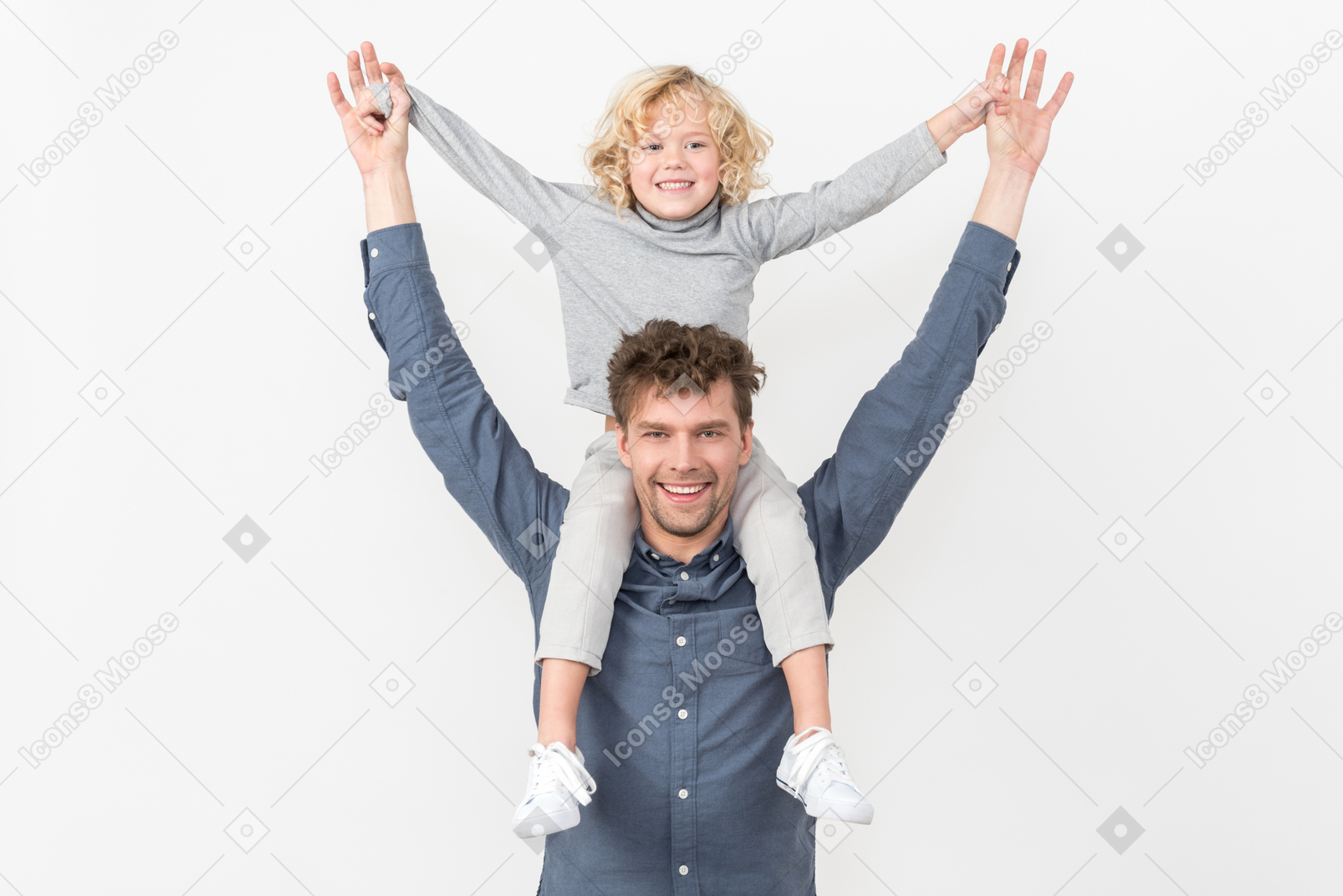 Boy sitting on his father's neck with their hands up