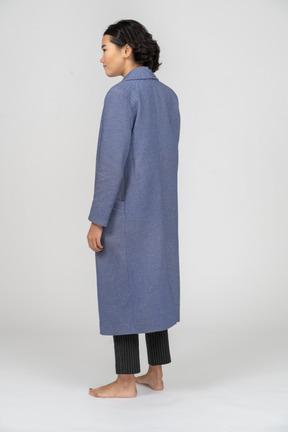 Vista posteriore di una donna in cappotto blu in piedi