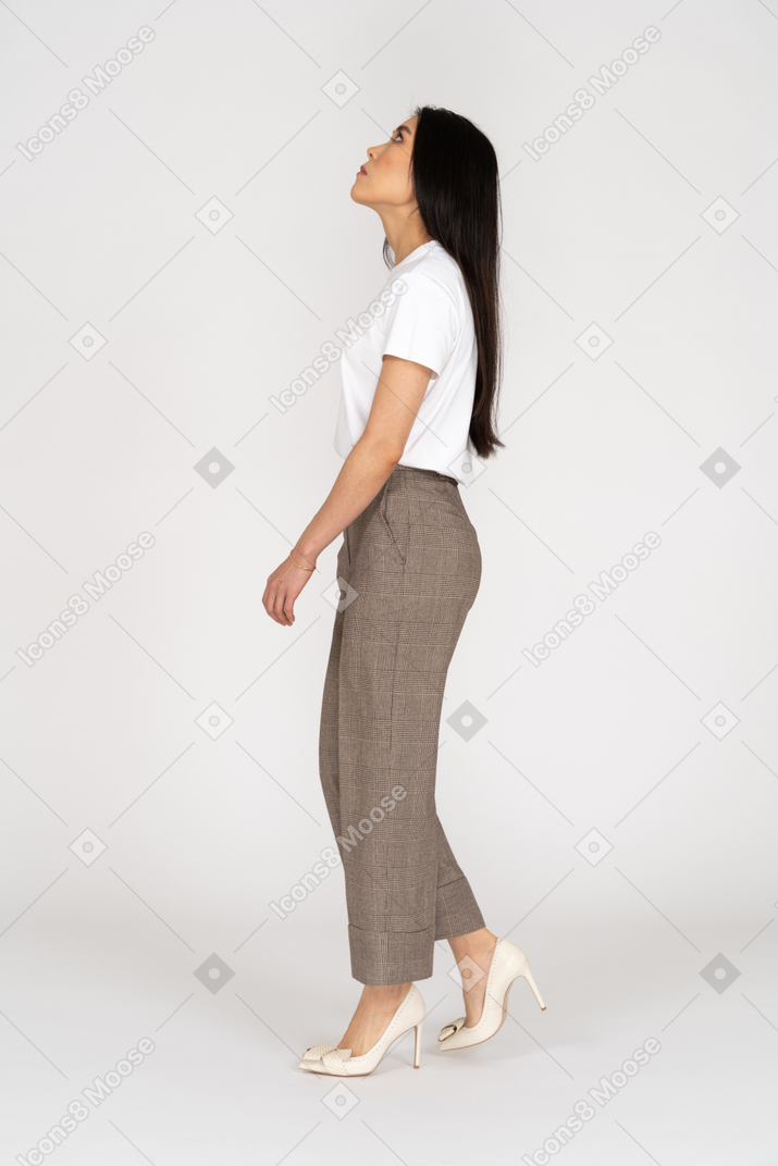 一位年轻的女士，穿着马裤和t恤，仰望的侧视图