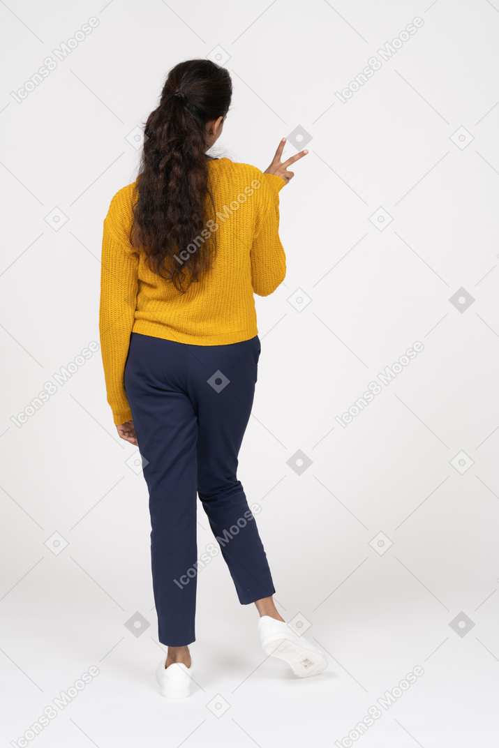 Vista posteriore di una ragazza in abiti casual che mostra il segno v
