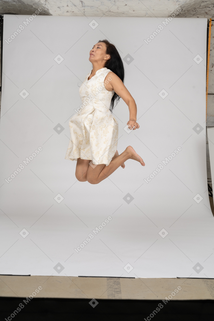 Женщина в красивом платье прыгает