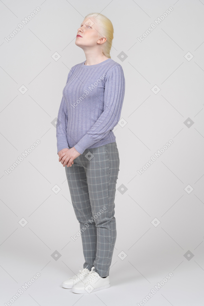 Young woman in casual clothes looking upwards