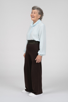 Вид в три четверти на пожилую женщину, улыбающуюся и подмигивающую левым глазом