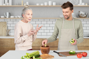 A man and woman in the kitchen preparing food