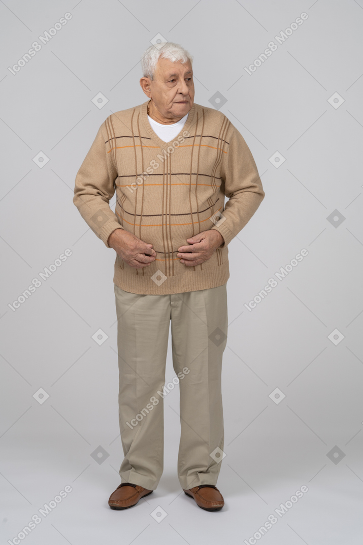 Вид спереди на старика в повседневной одежде, смотрящего в сторону