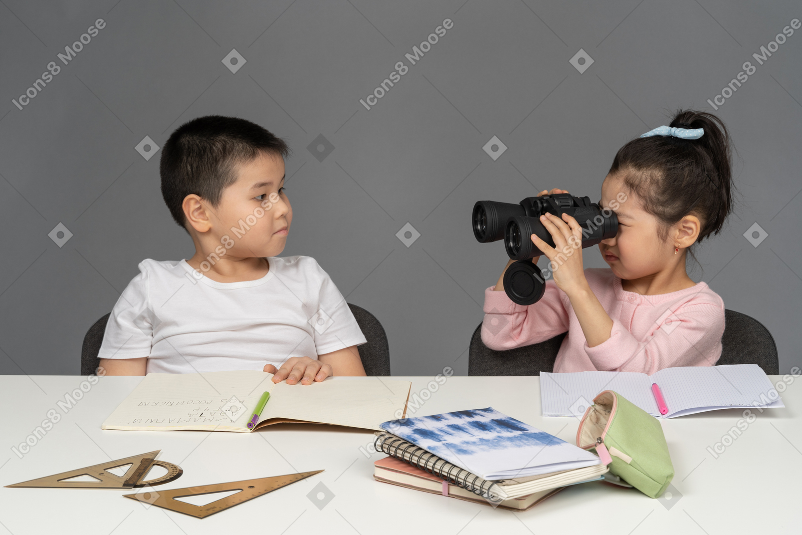 Little girl looking at her brother through binoculars