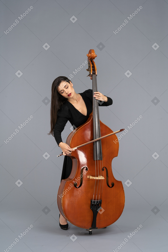 弓でコントラバスを演奏する黒いドレスを着た若い女性の正面図