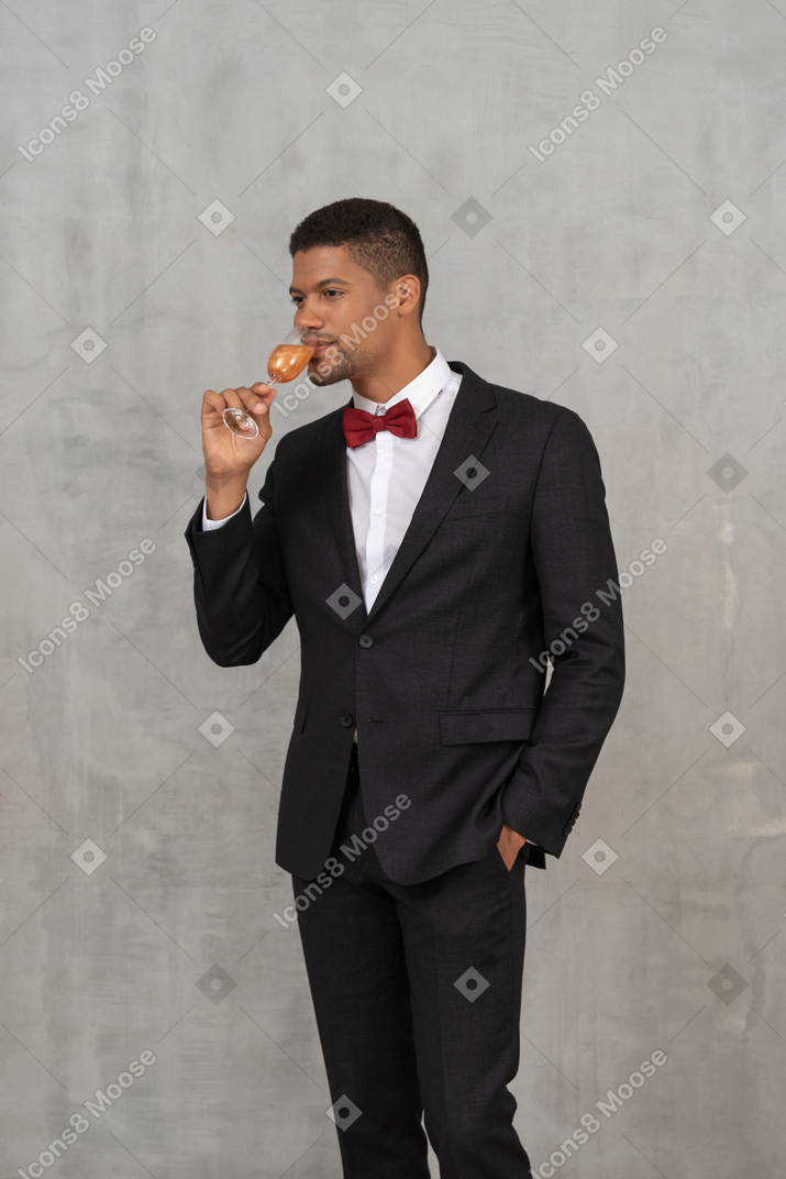 Well-dressed young man enjoying a glass of champagne