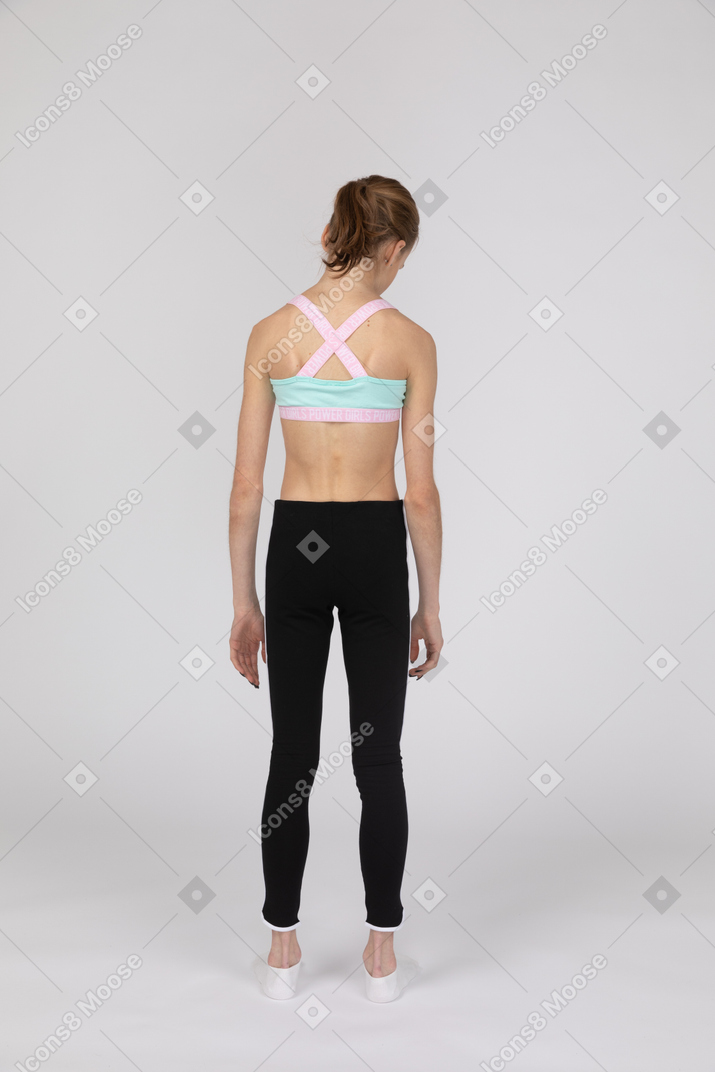 Vista traseira de uma adolescente em roupas esportivas olhando para baixo