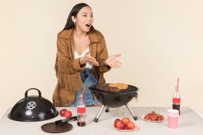 Mujer asiática joven preocupada haciendo una barbacoa