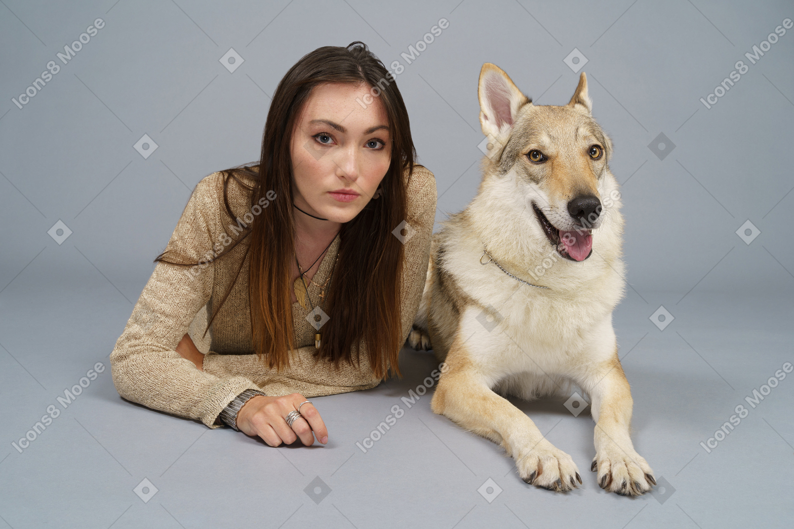 A figura intera di un maestro femmina sdraiato dal suo cane e guardando la fotocamera