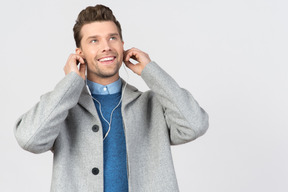 Jeune beau mec souriant et écoutant de la musique