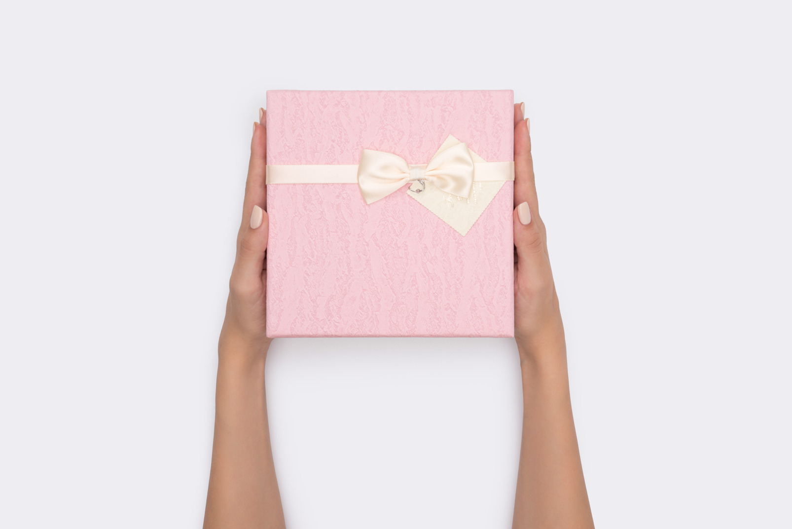 Female hands holding pink gift box