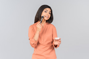 Indian woman applying face powder on her cheeks