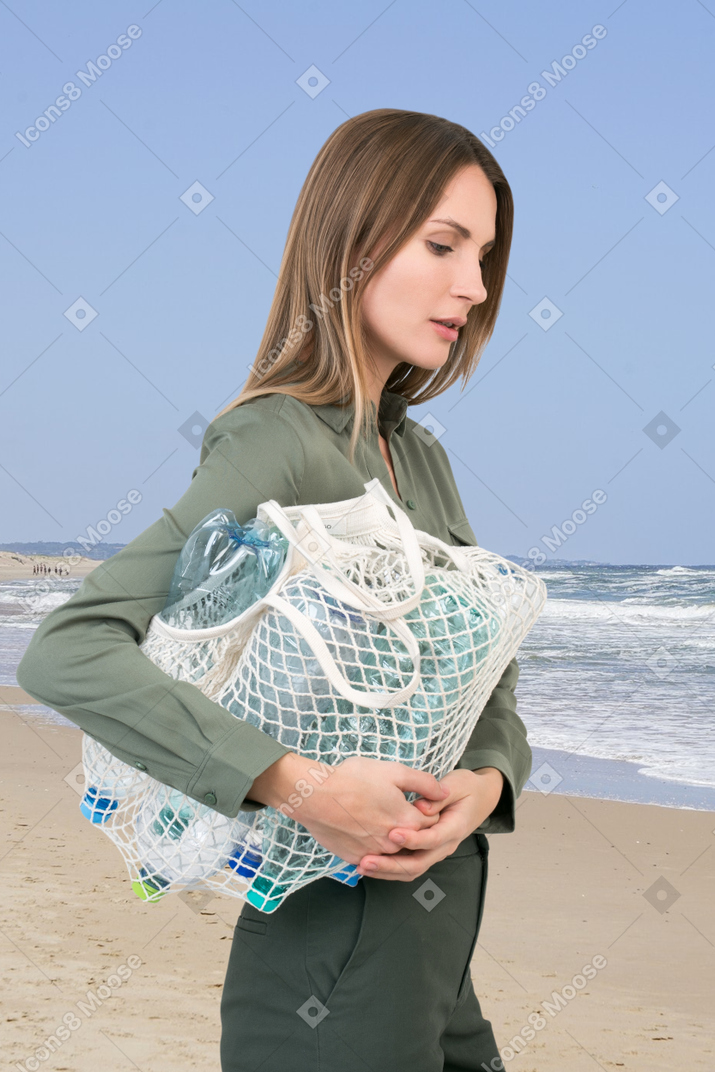 A woman carrying a bag on the beach