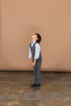 Side view of a boy in suit looking up