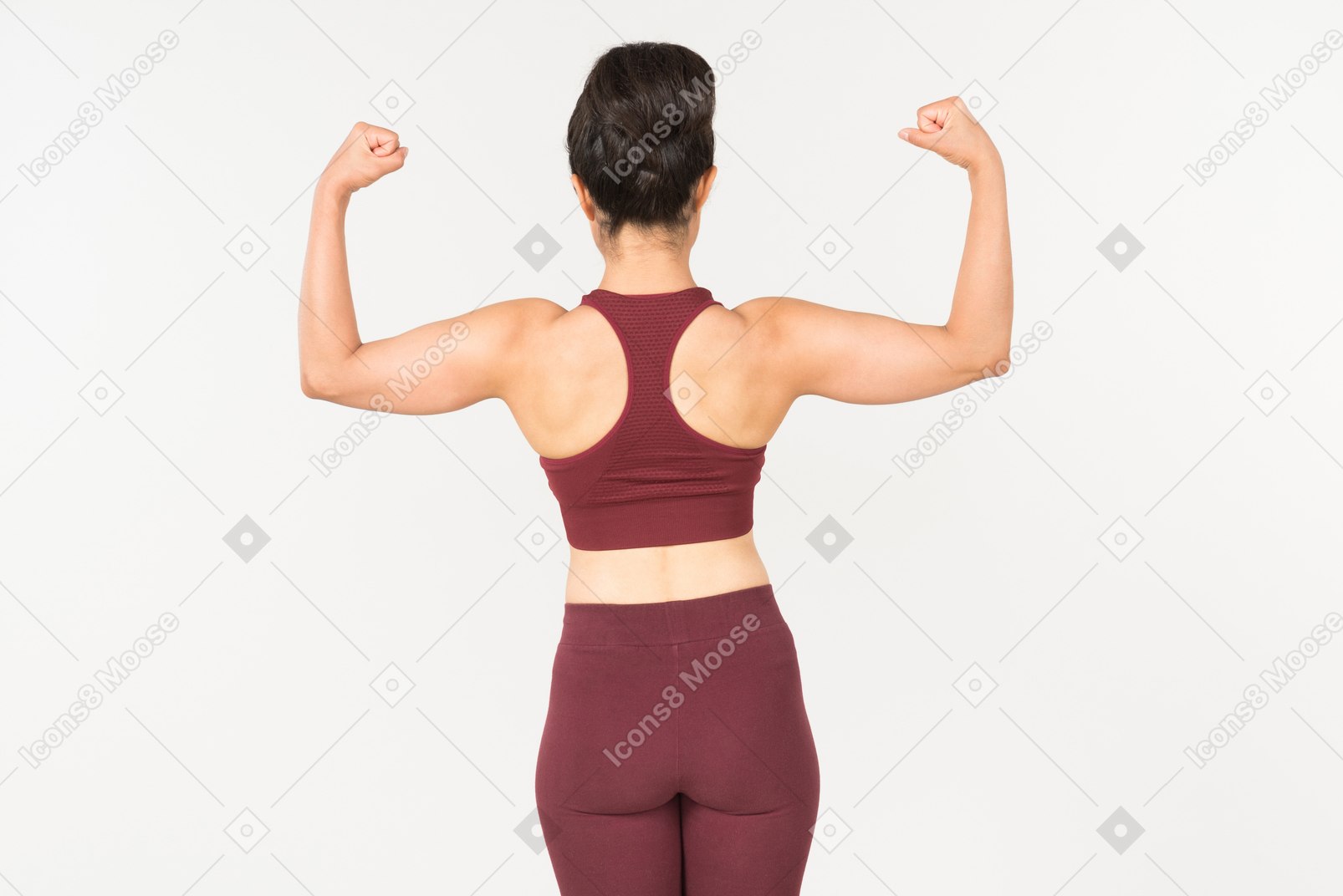 Giovane donna indiana in abiti sportivi che mostra i muscoli e in piedi di nuovo alla fotocamera