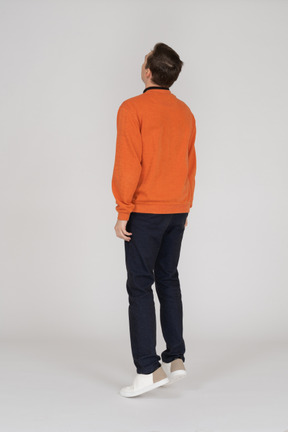 Junger mann im orange sweatshirt springen