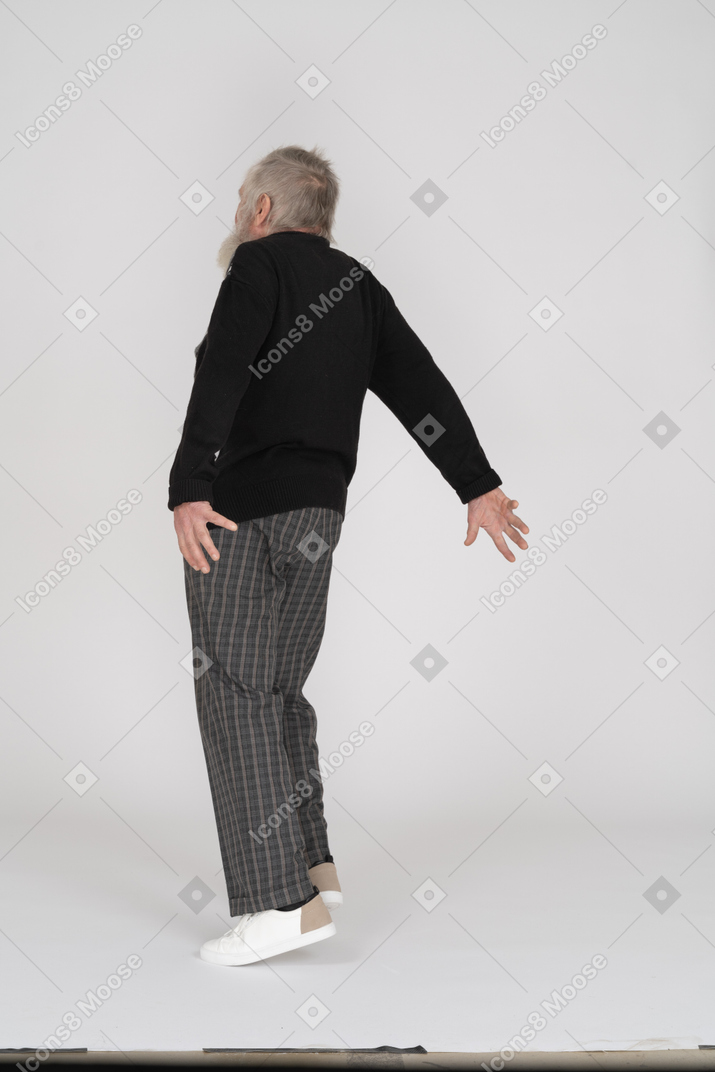 Elderly man standing with his arms extended backwards