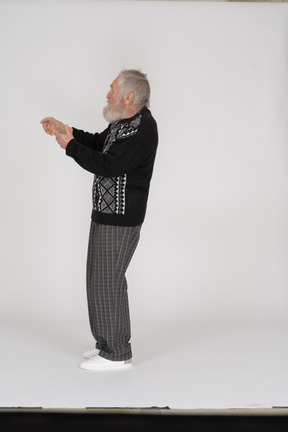 Side view of old man raising arms