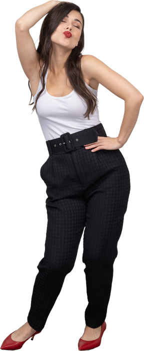 Front view of a confident young woman in office clothing posing and sending a kiss