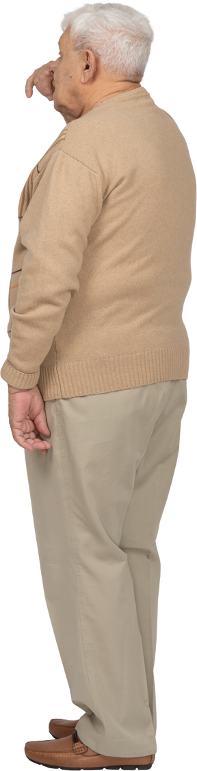 Vista posteriore di un uomo anziano in abiti casual che tocca il naso