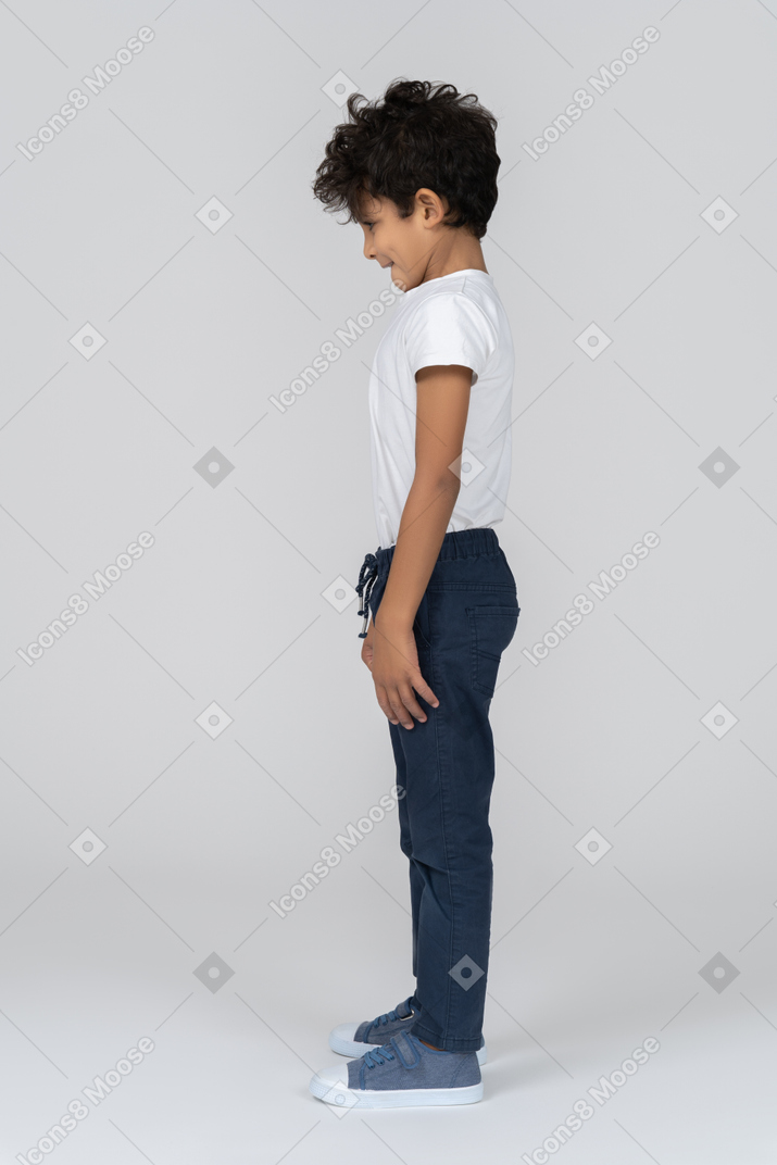 A boy standing with hands alongside body