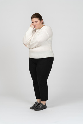 Front view of a tired plump woman in casual clothes looking at camera