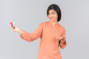 Indian woman pointing at lip balms she's holding