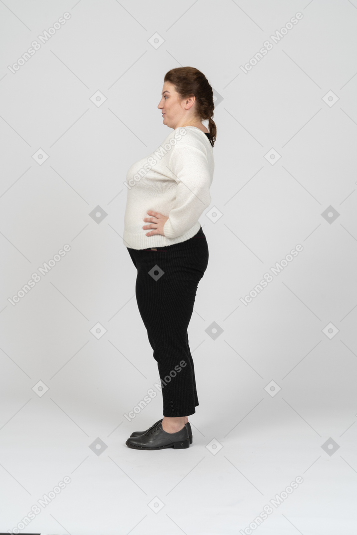 一个穿着休闲服摆姿势的胖女人的侧视图