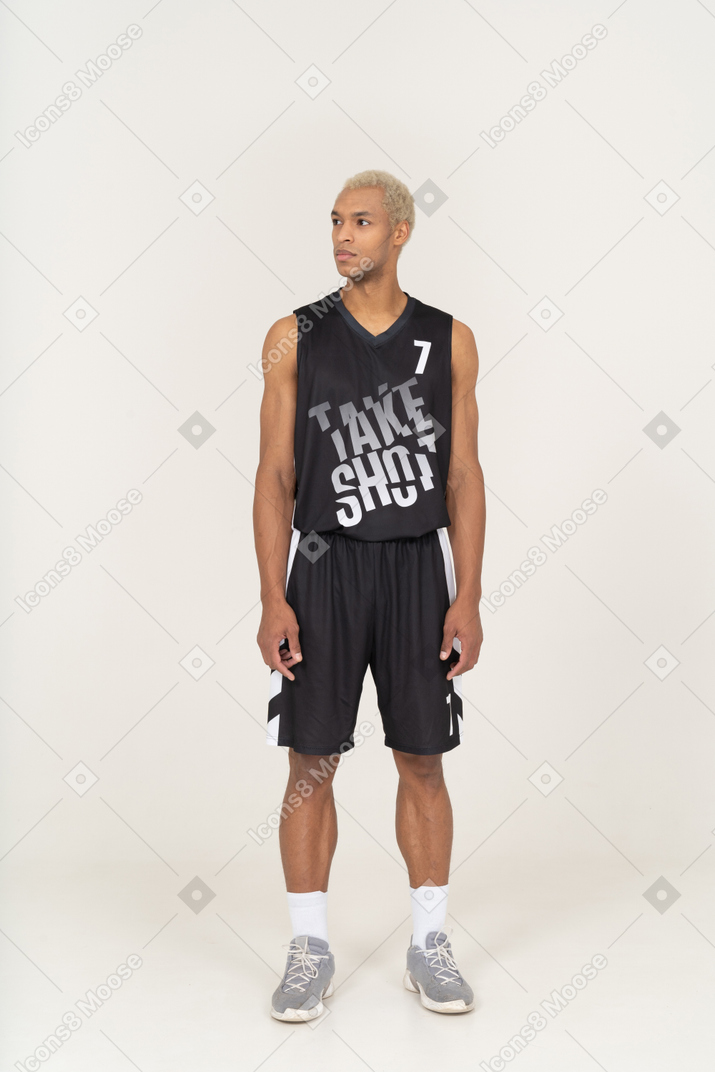 Front view of a young male basketball player standing still & looking aside