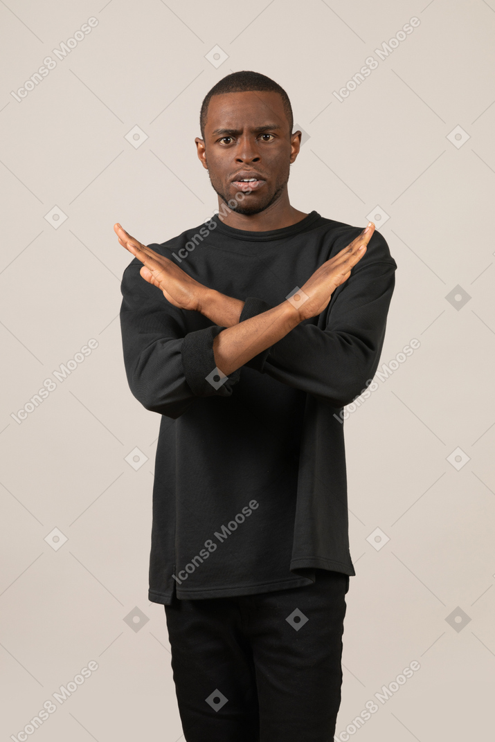 Young man staring at camera with crossed hands