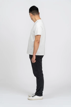 Man in casual clothes standing in profile and looking aside